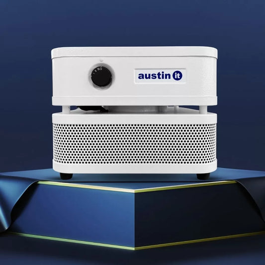 The Austin “it” Air Purifier, with a white body, black dial, and perforated base, is shown on a blue pedestal against a dark blue backdrop.