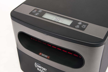 Close-up of a black and gray AirNmore® Comfort Buddy heater with an LED display showing 79°F, multiple control buttons on top, and a visible heater vent with safety warning label below the display.